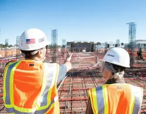two construction workers in safety vests at site